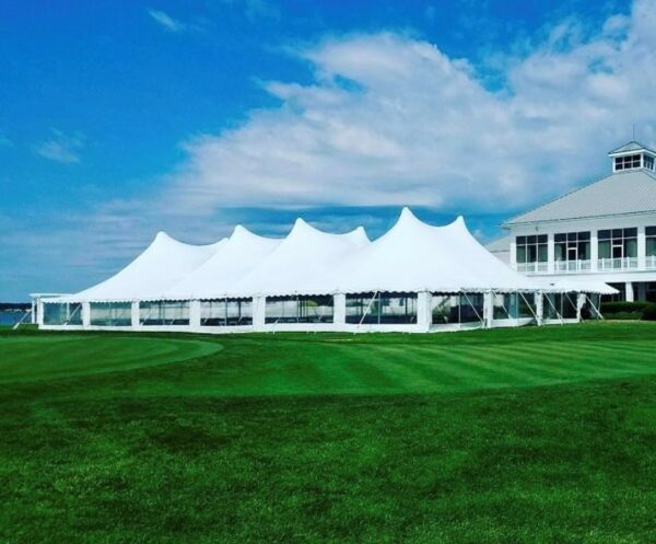 high peak pole tent on green lawn under blue sky, in Rehoboth Beach, Delaware