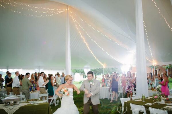 Bride and Groom under a tent with twinkle swag lighting