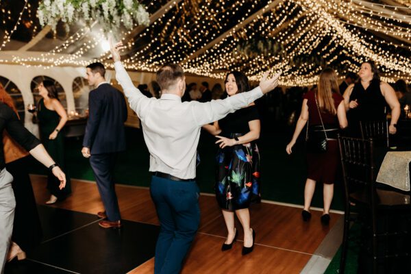 People dancing on Dancing Floor under wedding tent with waterfall lighting