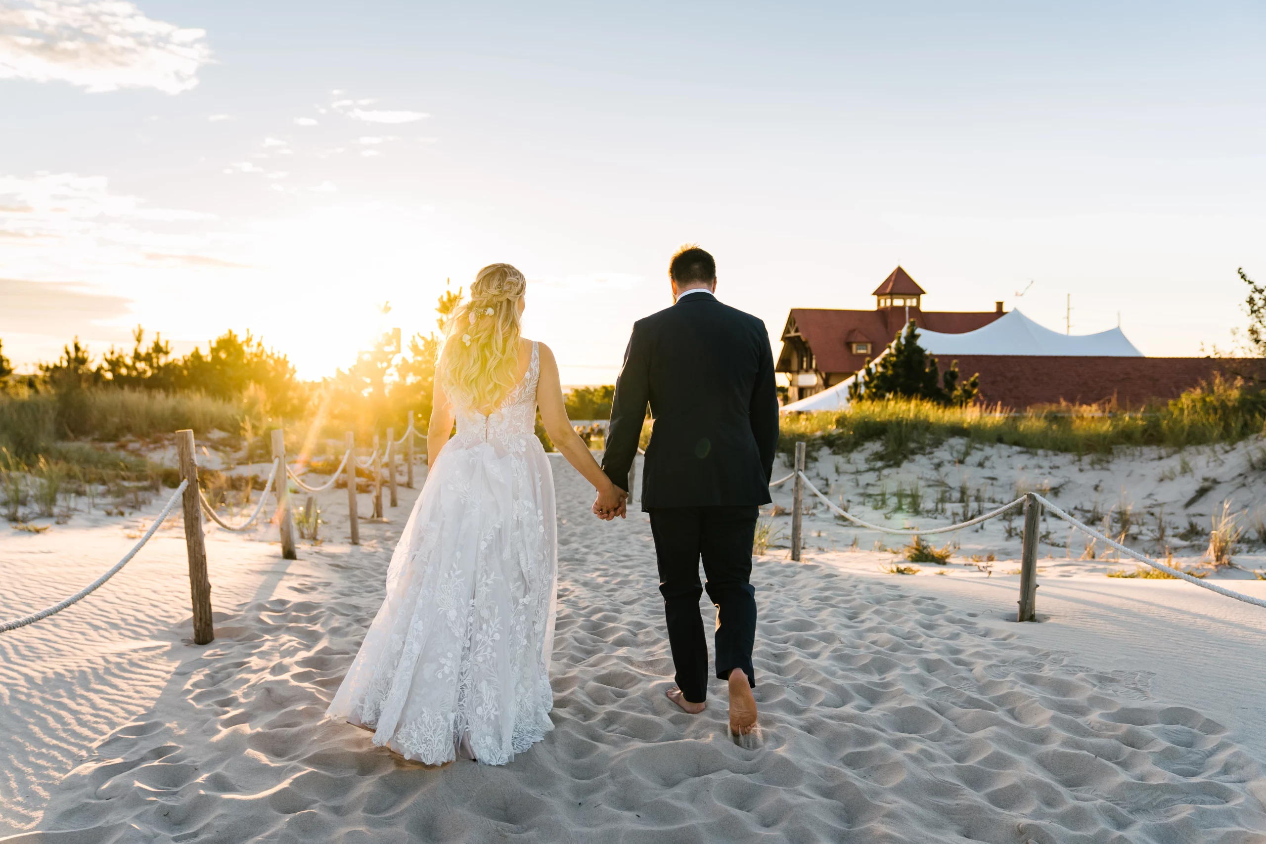 couple walking on beach wedding dress