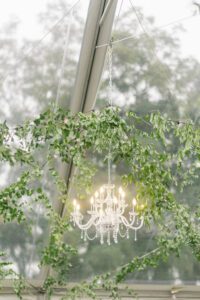 chandelier in clear ceiling tent with greenery 