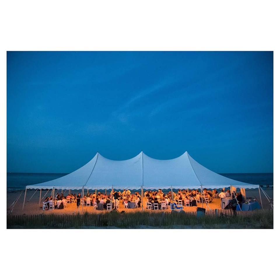 white wedding tent with lighting on beach at dusk in rehoboth beach