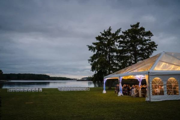 clear top tent with lighting at dusk next to water