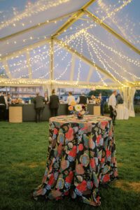 clear top wedding tent with draped twinkle lighting and table with floral linen