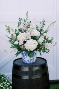 wine barrel with flowers in blue and white vase