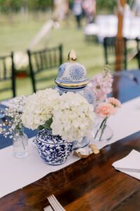 table with blue vase and white hydrangea floral center piece
