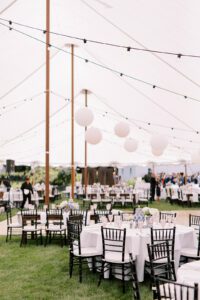 wedding tent with paper lanterns round tables and black chiavari chairs