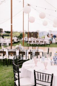 Wedding Tent with a mixture of round and long tables for guest seating, shown with chiavari chairs