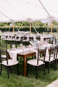 farmhouse tables with black chairs set up for wedding reception