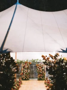 Exterior view of sailcloth tent with floral enriched ceremony design inside