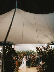 View from outside the sailcloth tent of the bride and groom at the altar