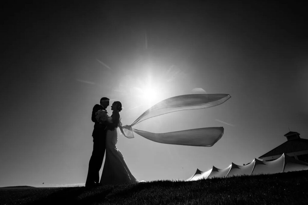 bride and groom black and white photo with wedding tent