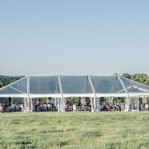 clear top frame tent with hip ends, set up in grass meadow