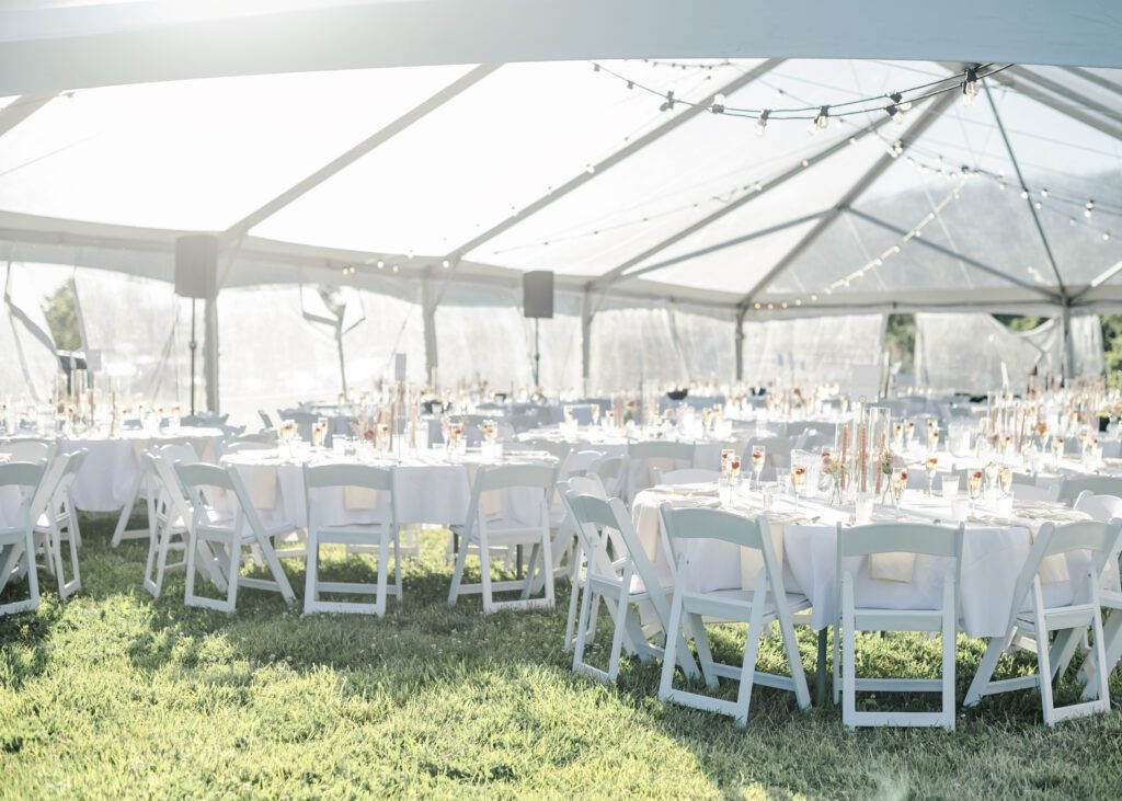 clear top wedding tent with white linens and chairs