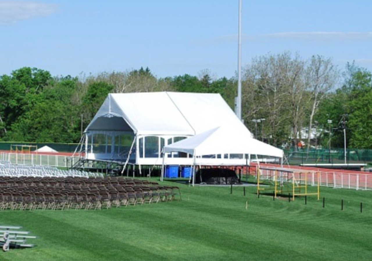 View of a graduation with a bandshell tent over a stage