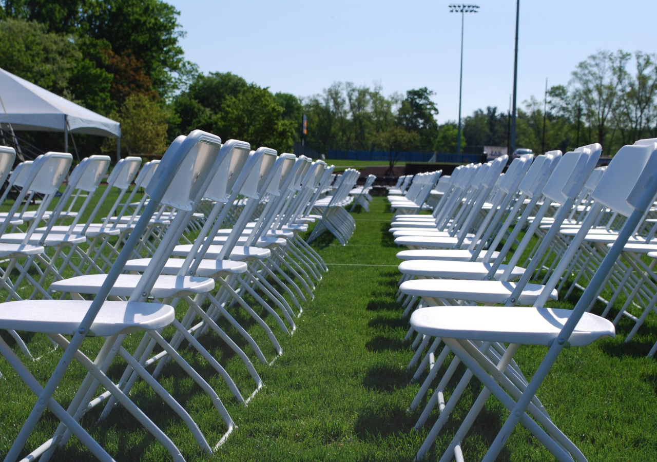 Up close view of white folding chairs in rows for a collegiate graduation ceremony
