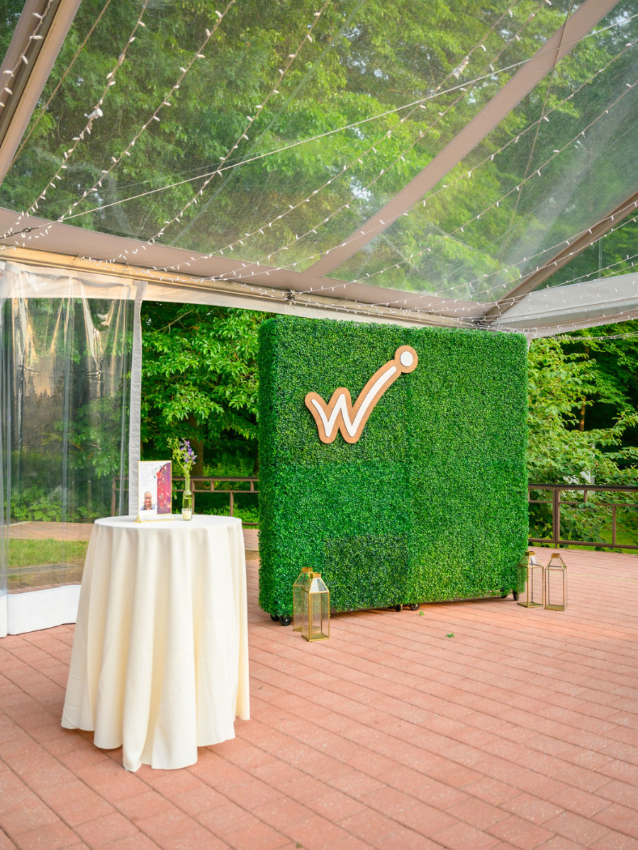 Westside logo backdrop next to a cocktail table underneath a cleartop tent