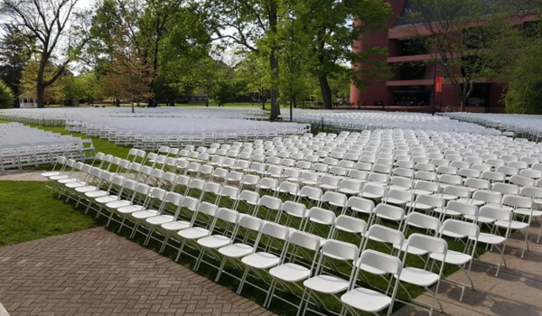 View of white chairs lined up for a college graduation outdoors