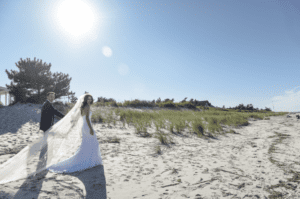 Bride and Groom walking across the beach