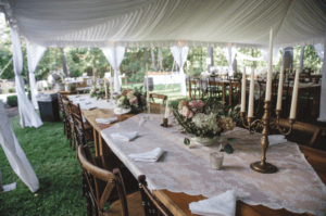 Inside a frame tent with a liner, view of a farm table