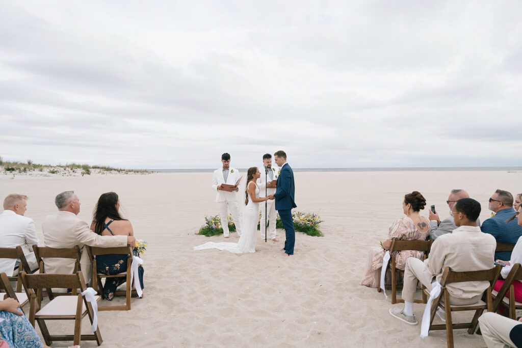 wedding ceremony on sandy beach with bride and groom