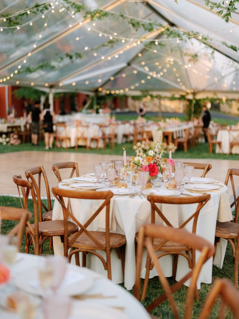 clear tent set up with garland draped from ceiling