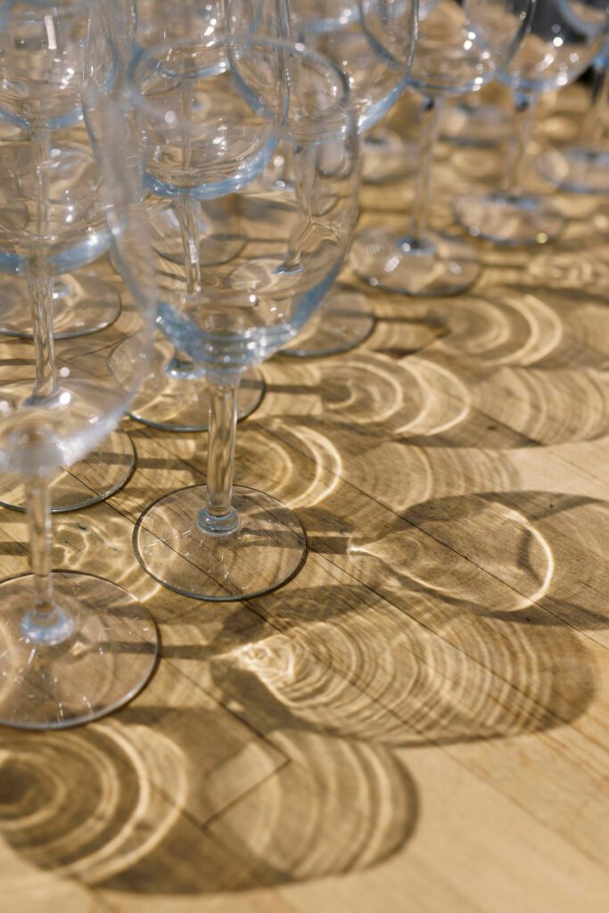 glassware reflecting sunlight on wooden table