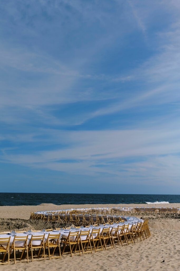 beach with al fresco dining tables and chairs set up on the sand