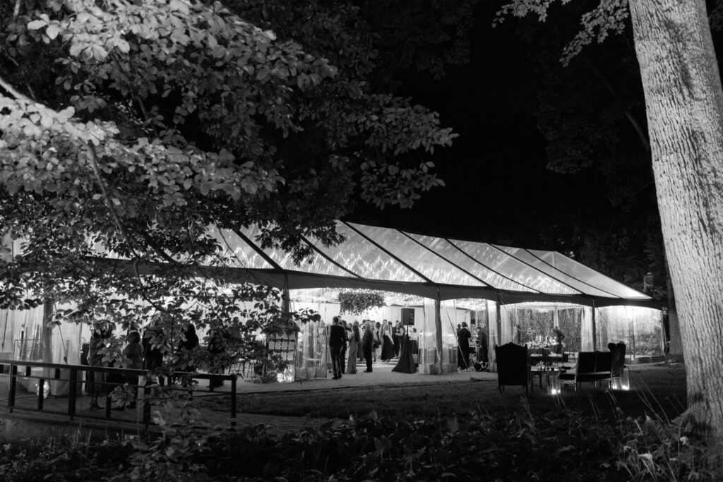 black and white photo of clear top wedding tent with twinkle lighting