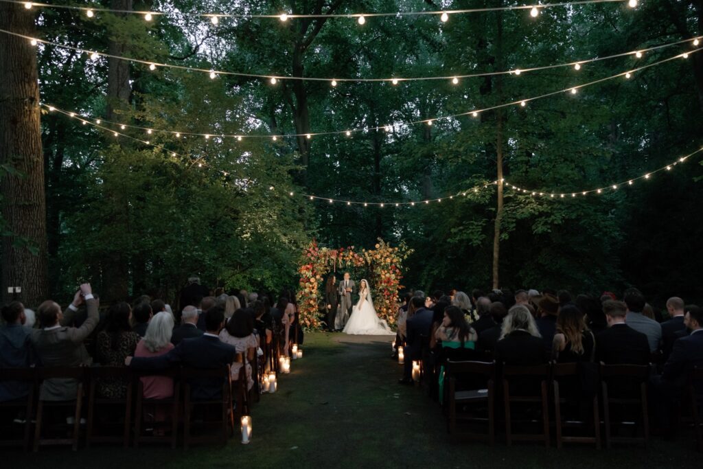 outdoor wedding ceremony with overhead lights suspended in trees