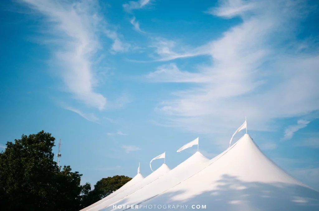 sailcloth tent flags flowing in the breeze under a blue sky.