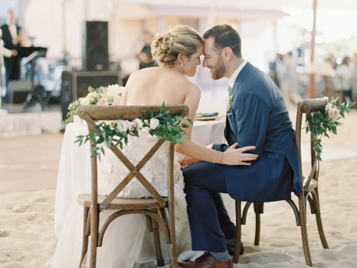 Bride & Groom sitting on crossback chairs at a sweetheart table