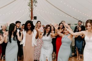 wedding guests dancing under reception tent