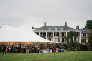 large white tent set up in lawn infront of stone estate for a wedding in Malvern PA