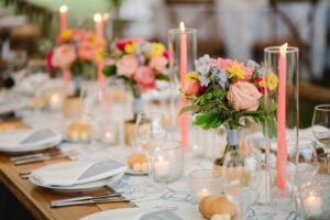 farmhouse tables filled with florals and peach colored candle center pieces for wedding