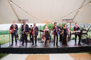 wedding band set up on stage under wedding reception tent