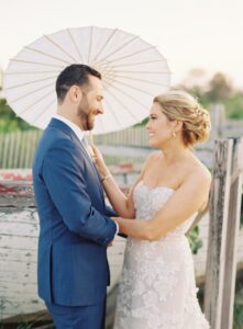 bride and groom holding umbrella