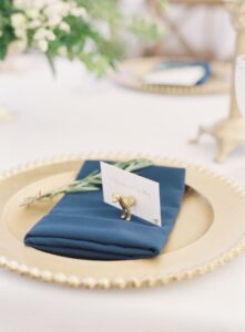 gold charger plate with navy blue napkin