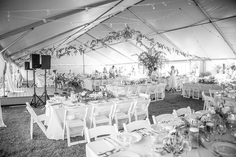 Freeman Foundation summer social 2025 large white tent with greenery draping, and tables and chairs set up underneath.