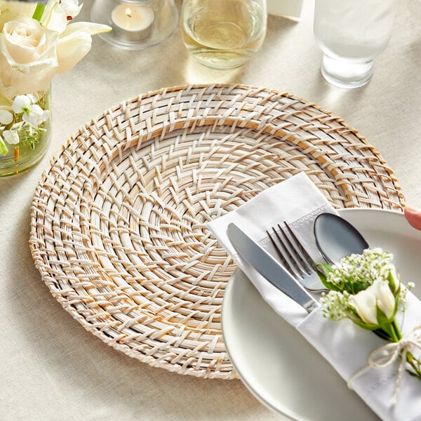 light blond rattan charger plate set on table with silverware setting